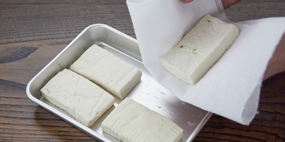 白和えの作り方。水切りした豆腐は、表面の水分もきちんと拭き取り、徹底的に水分を取り除きます。